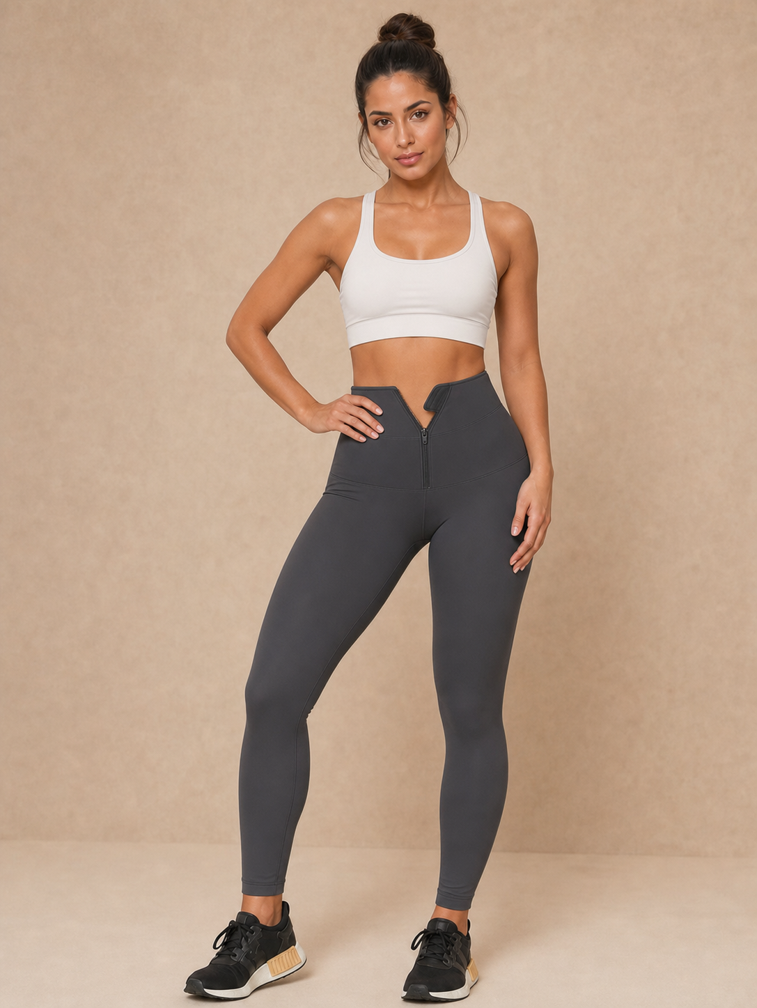 Modelo vestindo legging fitness feminina em poliamida com cintura alta em fundo bege.